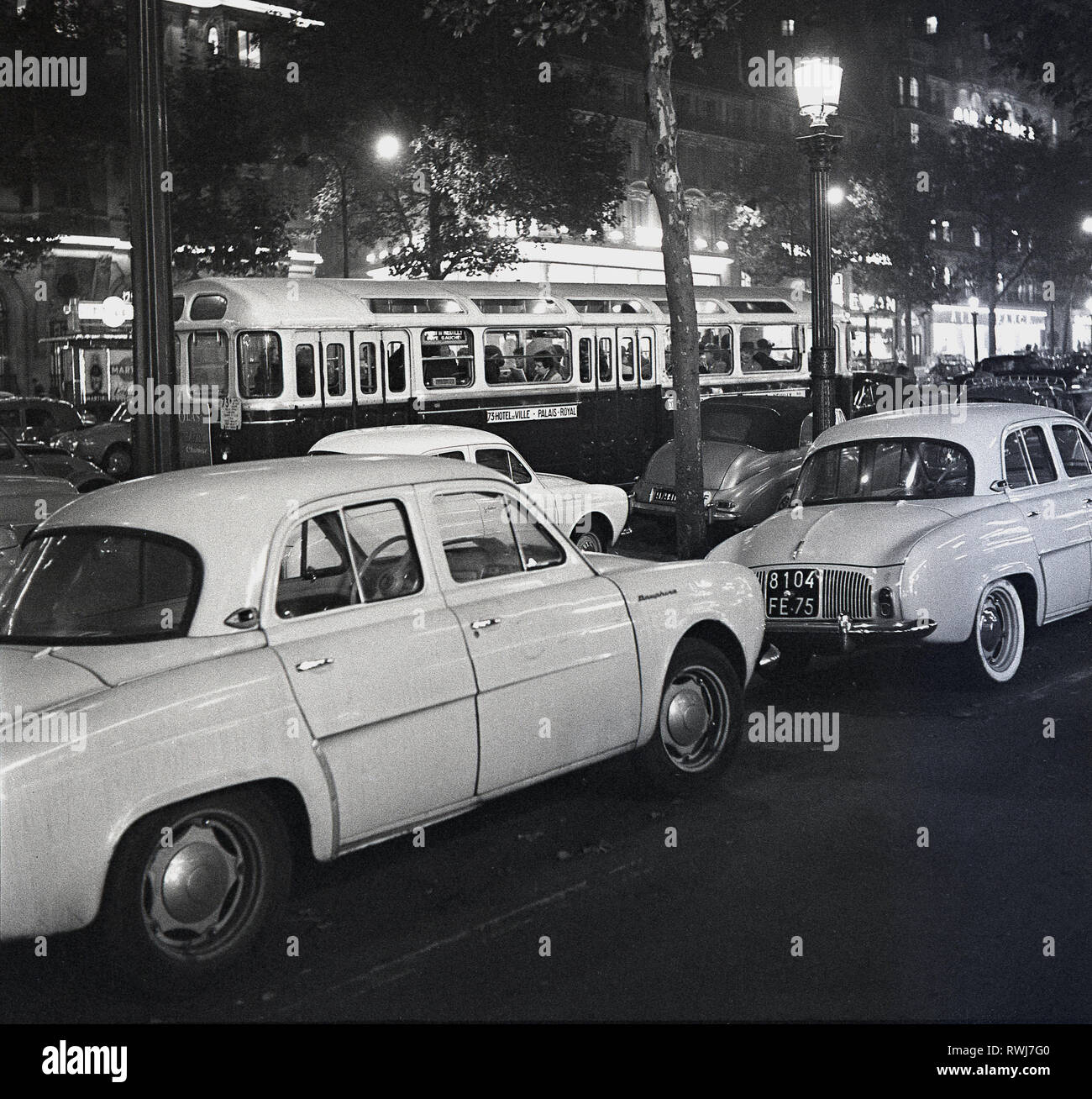 Années 1950, Paris la nuit, les voitures de l'époque garée près de l'Avenue des Champs-Elysées. Banque D'Images