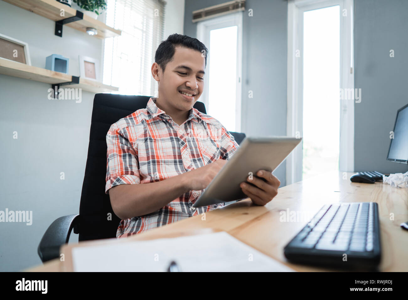 Propriétaire de l'entreprise à l'aide de relaxation à son bureau Banque D'Images