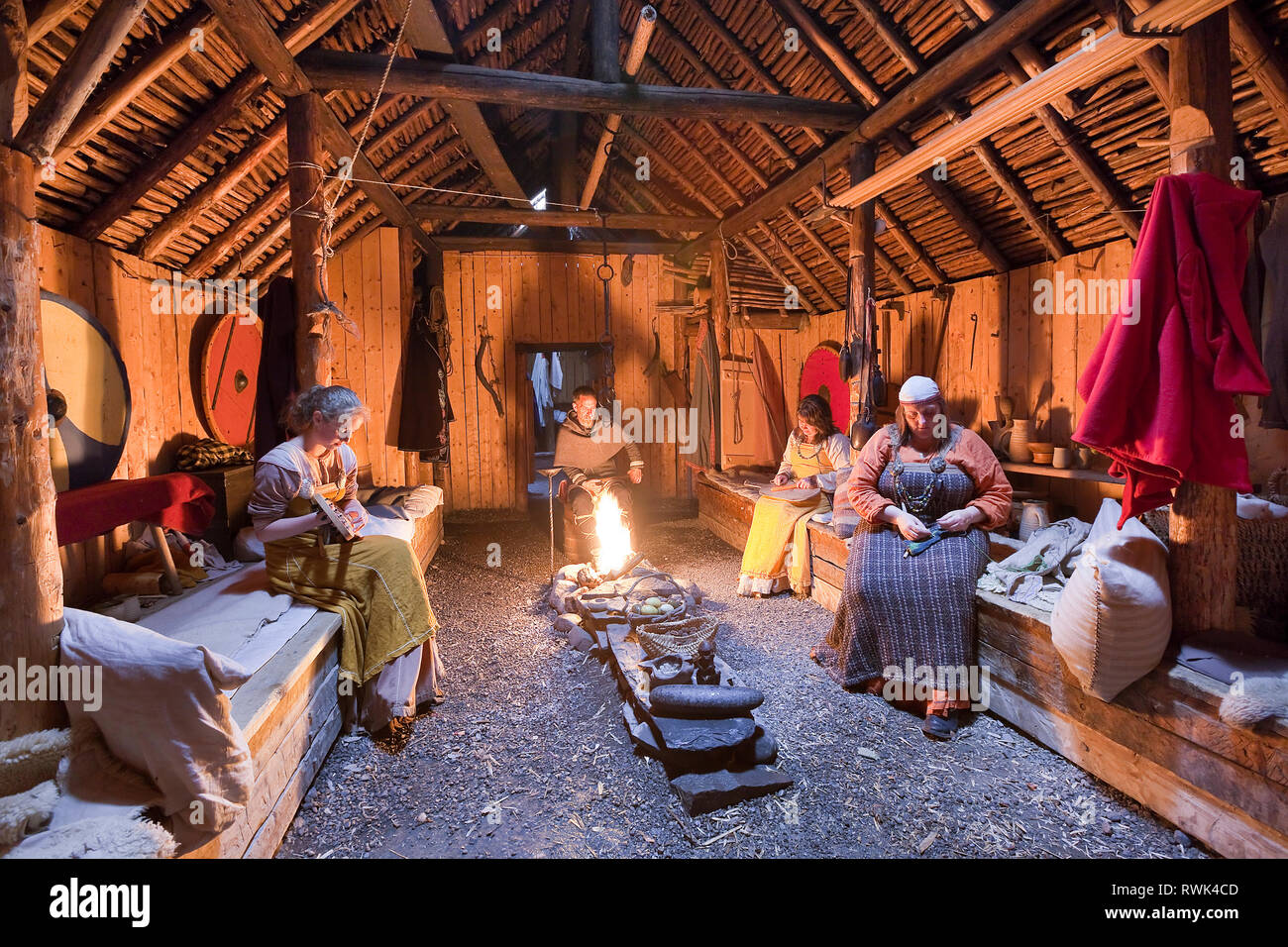 Parcs Canada les interprètes en costumes d'effectuer des tâches traditionnelles à l'intérieur d'une maison longue Viking recréé à L'Anse aux Meadows National Historic Site, L'Anse aux Meadows, Terre-Neuve, Canada Banque D'Images