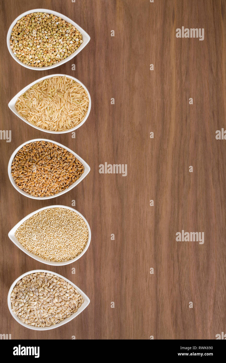 Un assortiment de grains entiers dans des bols sur un fond de bois Banque D'Images