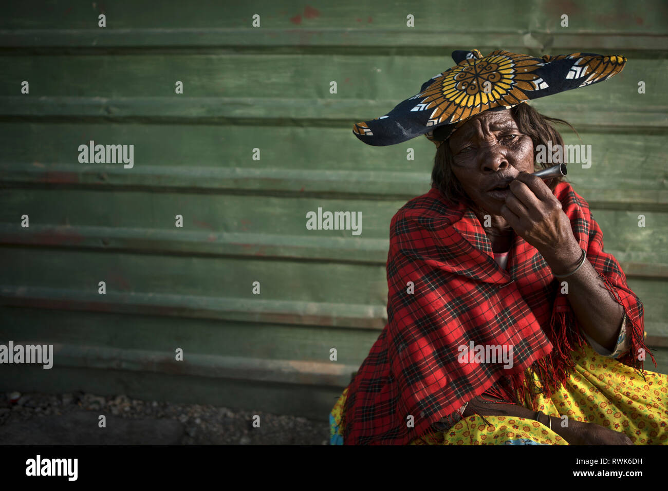 Une Femme Herero fumer à l'extérieur d'un magasin dans les Purros, la Namibie. Banque D'Images