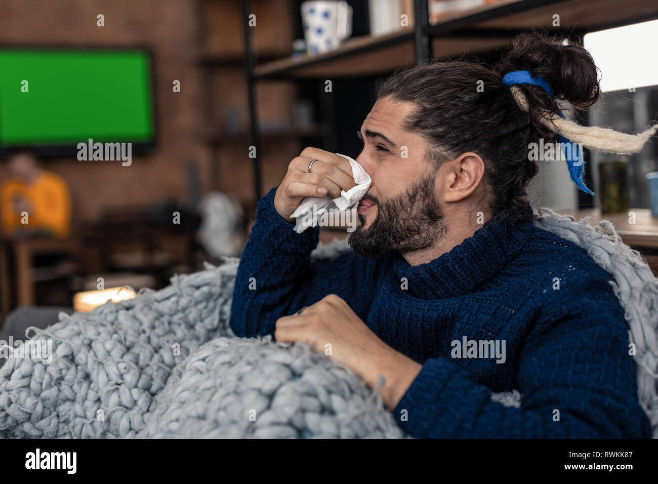 Triste agréable jeune homme tenant son nez Banque D'Images