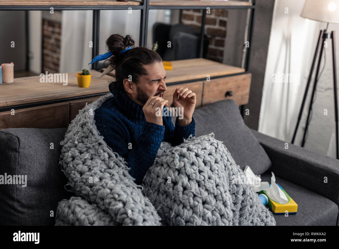 Triste homme malade étant couverts de plaid Banque D'Images