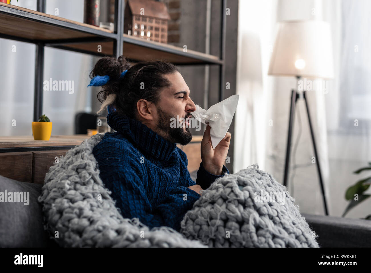 Malheureux homme malade à l'aide d'un mouchoir en papier Banque D'Images