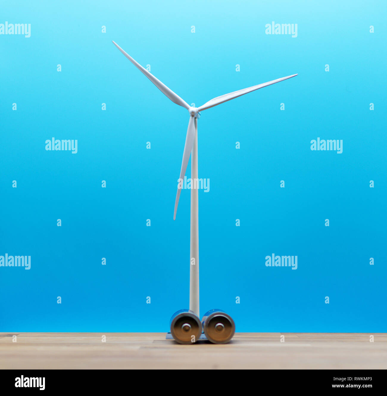 Symbole pour la sauvegarde de l'énergie éolienne. Un modèle wind turbine in derrière deux batteries. Banque D'Images
