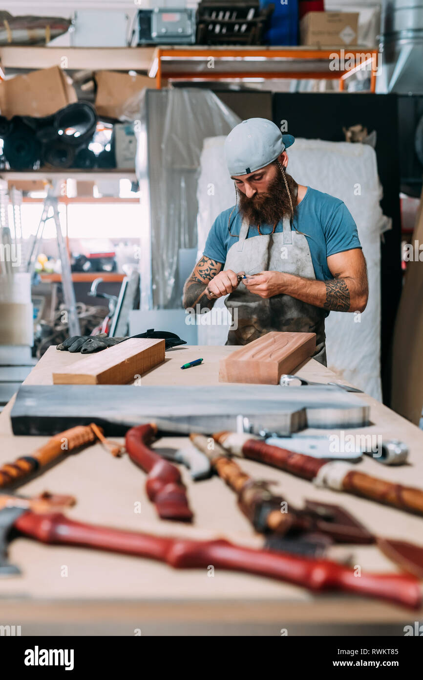 Ax travaillant sur le bois pour manche de hache en atelier Banque D'Images