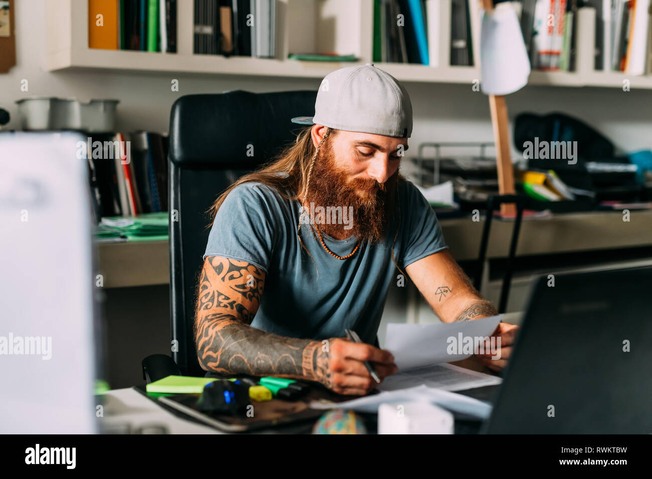Propriétaire de petite entreprise doing paperwork in office Banque D'Images Propriétaire de petite entreprise doing paperwork in office Banque D'Images