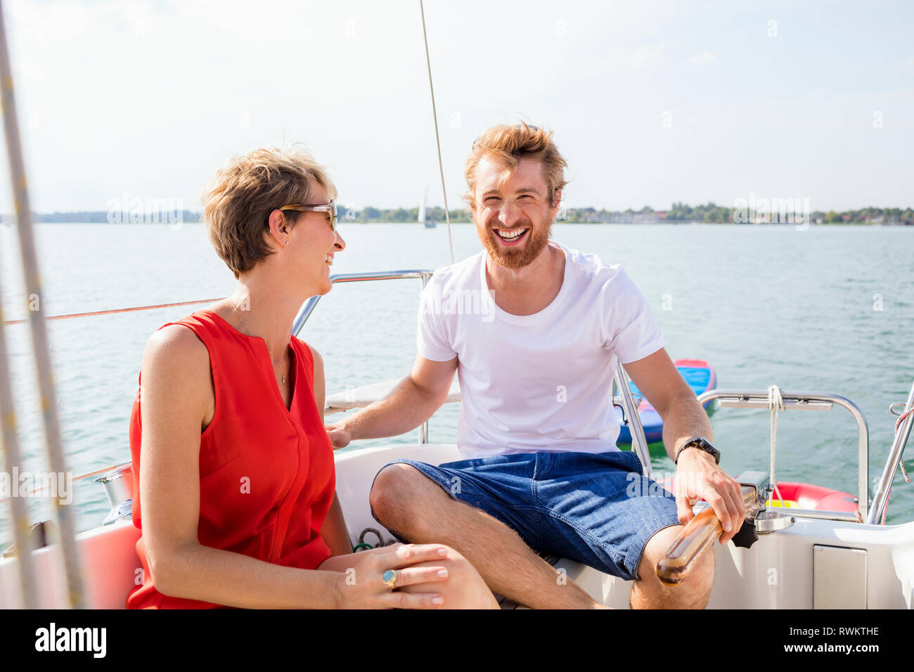 Jeune et mature woman laughing sur voilier sur le lac de Chiemsee, en Bavière, Allemagne Banque D'Images