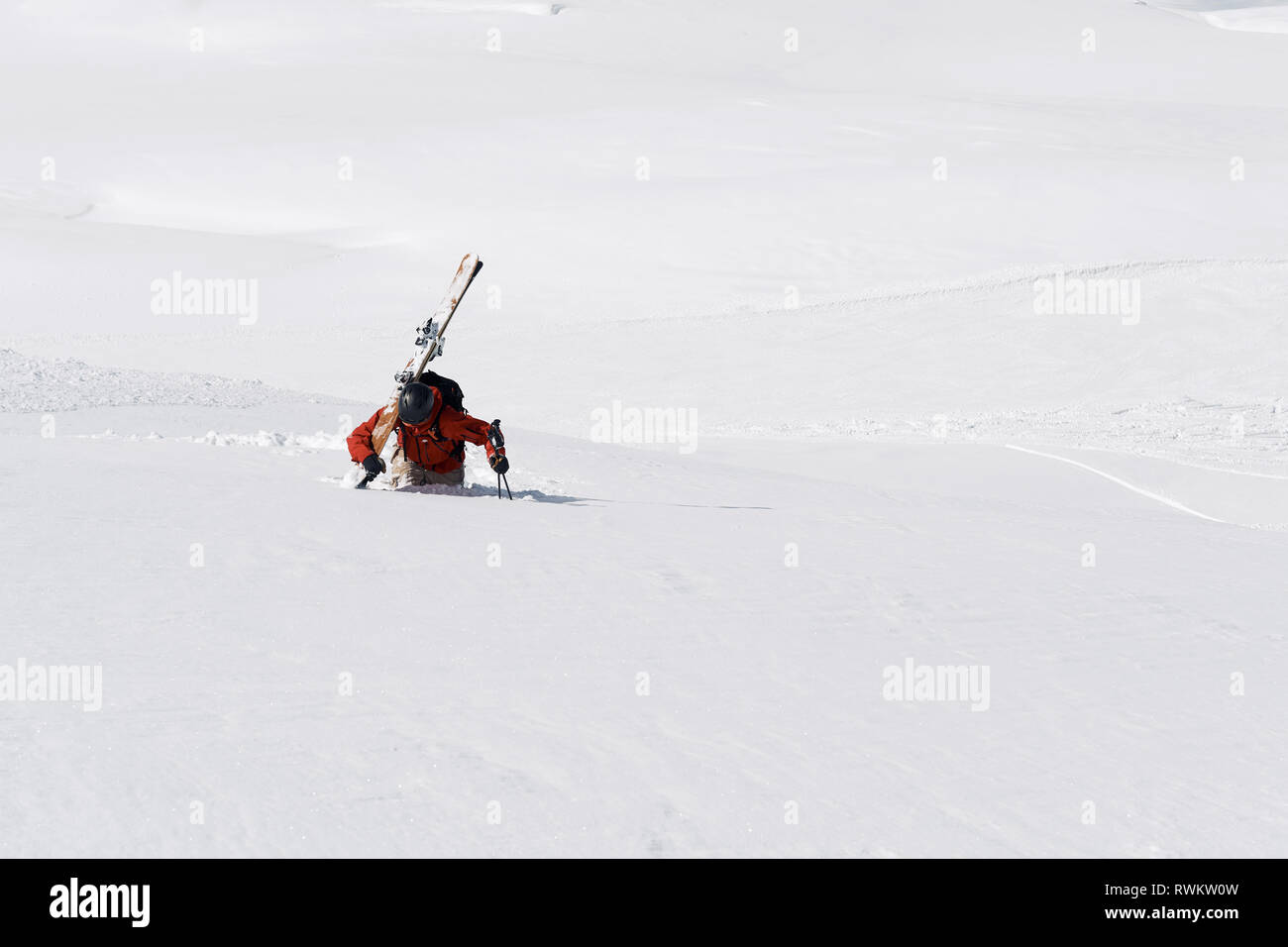 Trudging Male skier jusqu'mountain dans la neige profonde, l'Alpe-d'Huez, Rhône-Alpes, France Banque D'Images