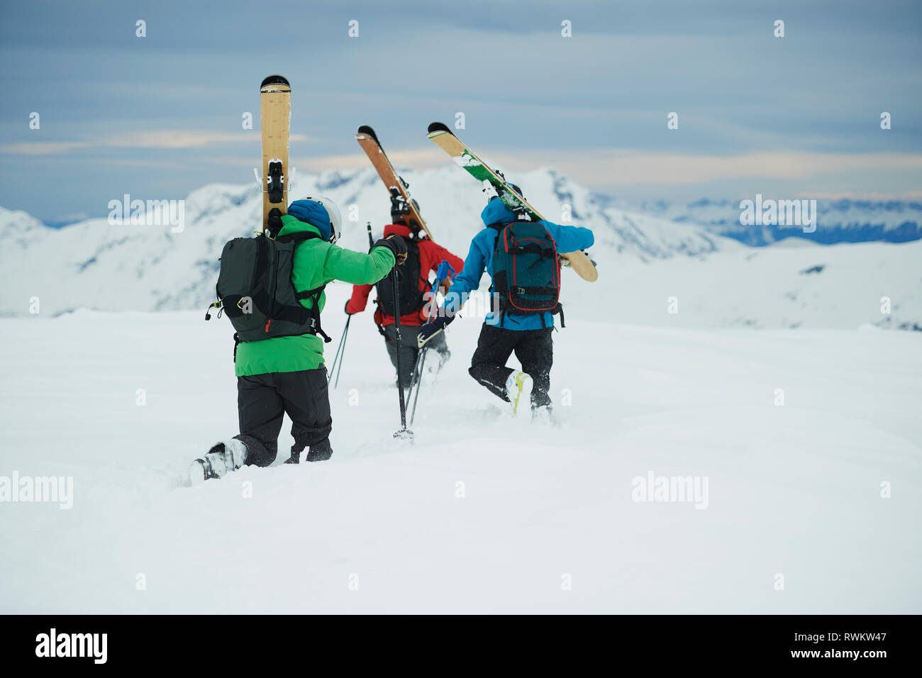 Paysage avec trois skieurs hommes voguant vers la montagne, vue arrière, Alpe-d'Huez, Rhône-Alpes, France Banque D'Images