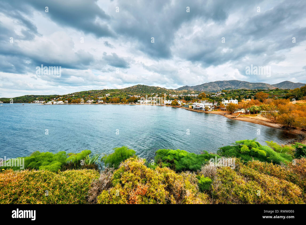 Vue de la baie de Gumusluk Moody et village de Bodrum, Mugla, Turquie sur une journée d'hiver. Belle mer calme, ciel et paysage de prairie. Banque D'Images