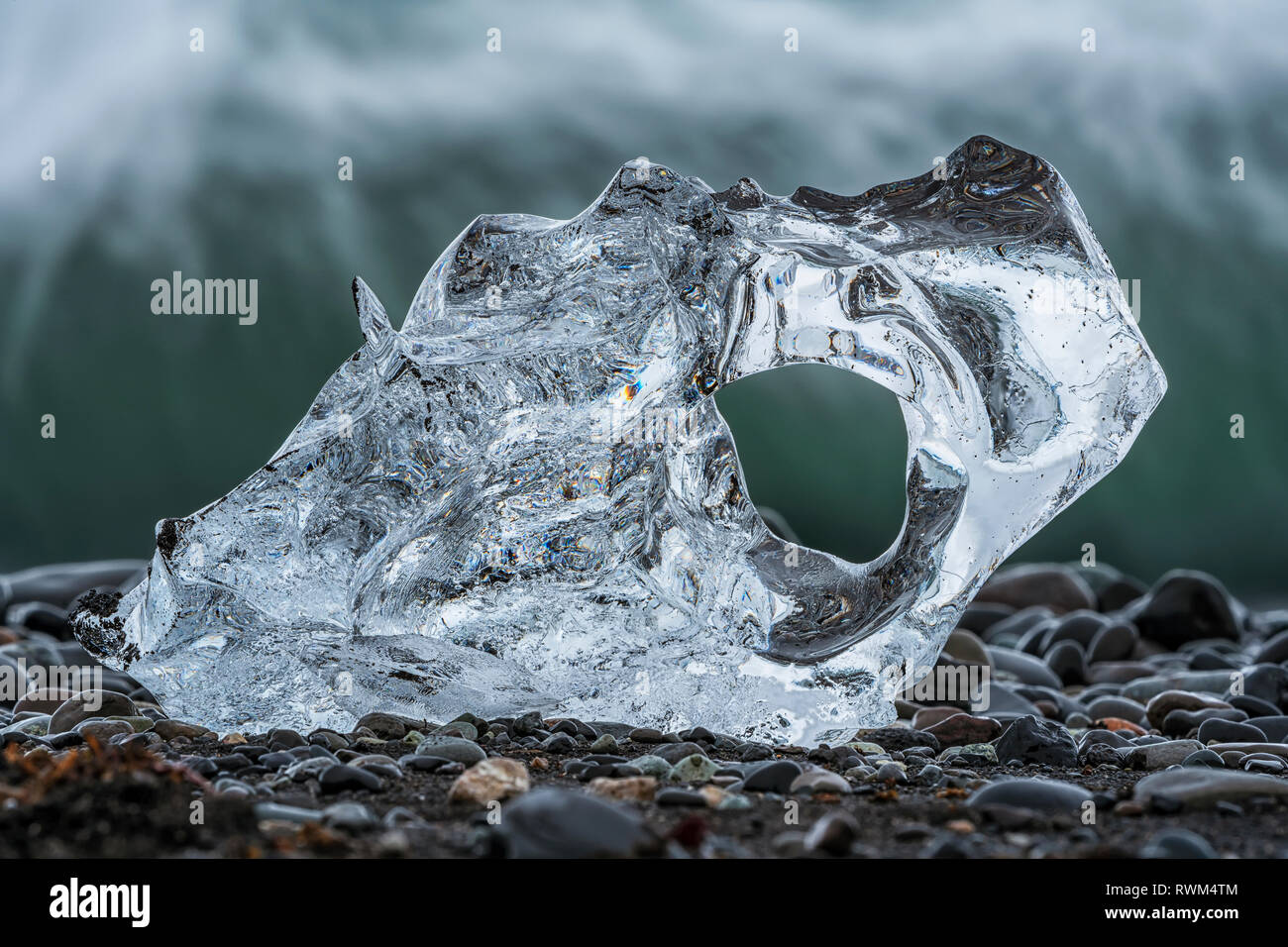 Morceau de glace sur la plage du Diamant, près de Jokusarlon, avec l'océan derrière elle le long de la côte sud de l'Islande, Islande Banque D'Images