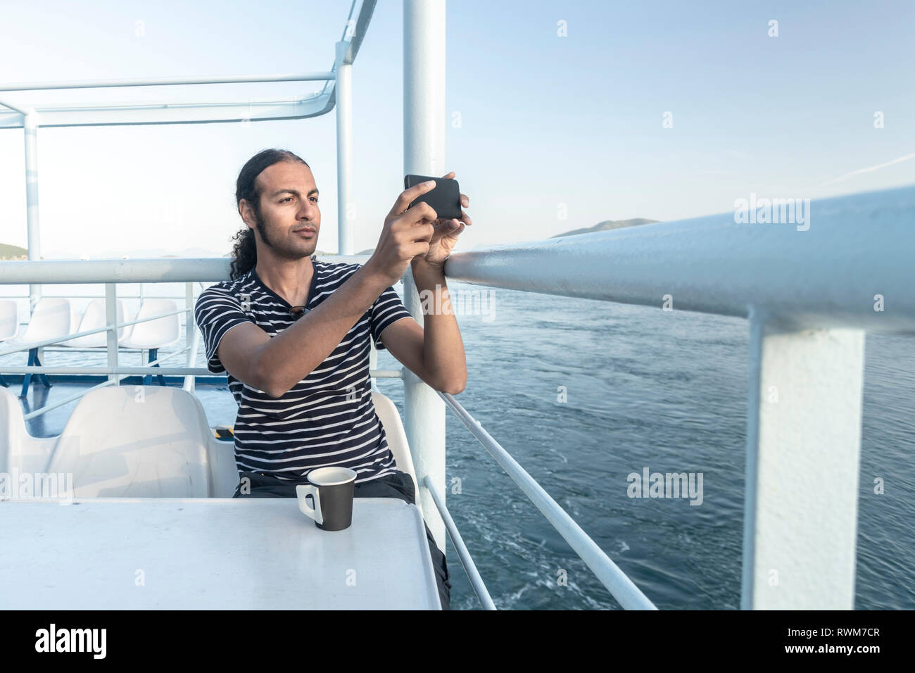 L'homme sur un bateau de croisière taking photograph Banque D'Images