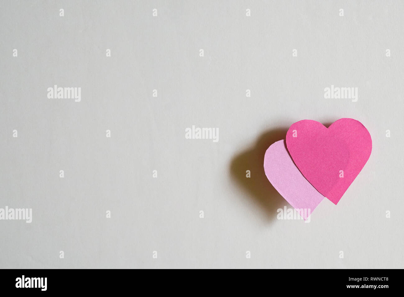 Love concept : deux coeurs en papier avec ombre sur un fond blanc Banque D'Images