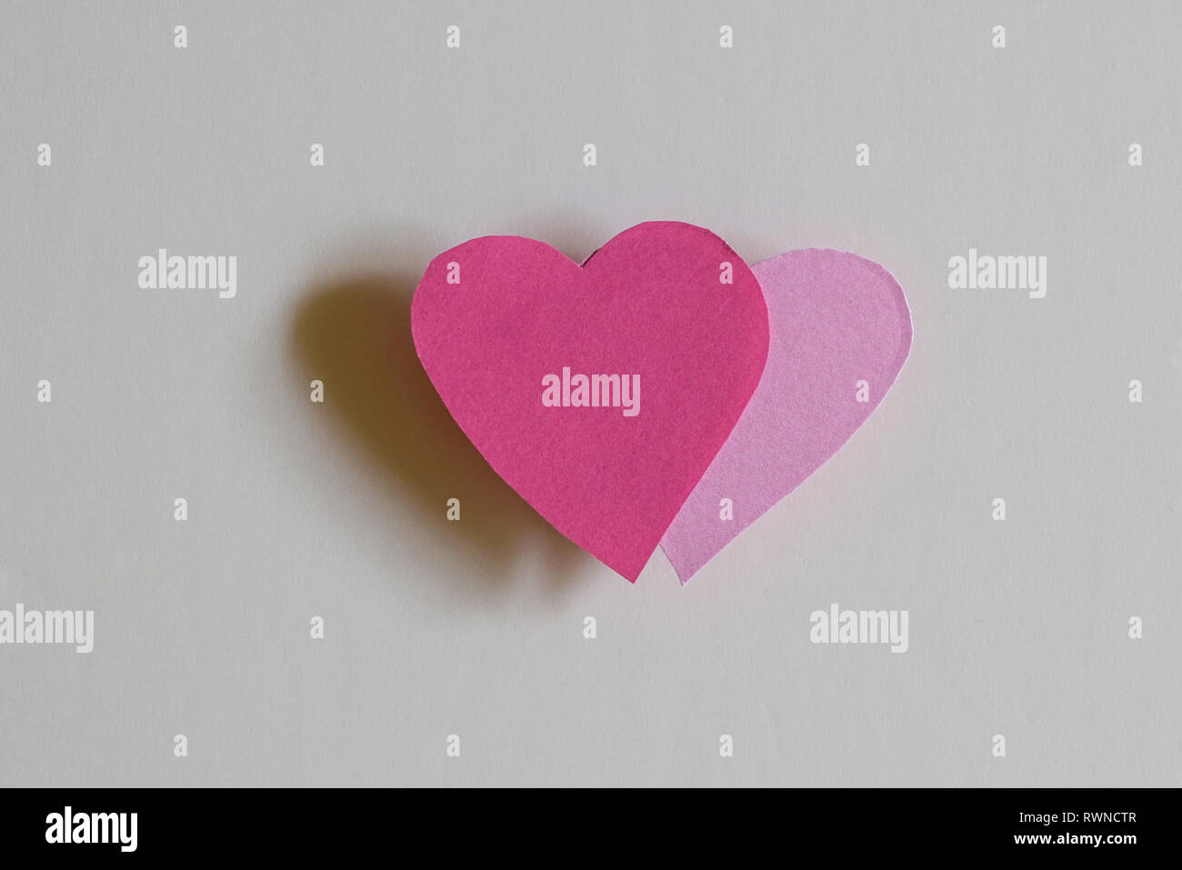 Love concept : deux coeurs en papier avec ombre sur un fond blanc Banque D'Images