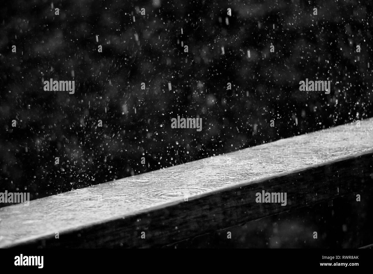 La pluie frappant une planche en bois au cours d'une tempête avec des gouttes de pluie qui rebondit. Banque D'Images