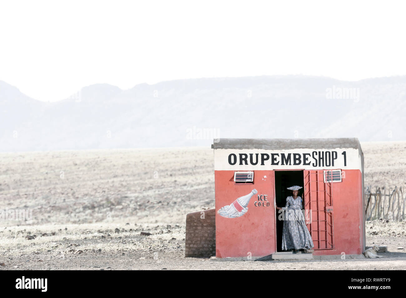 Une Femme Herero par une boutique dans la région de Kunene arides du nord de la Namibie. Banque D'Images