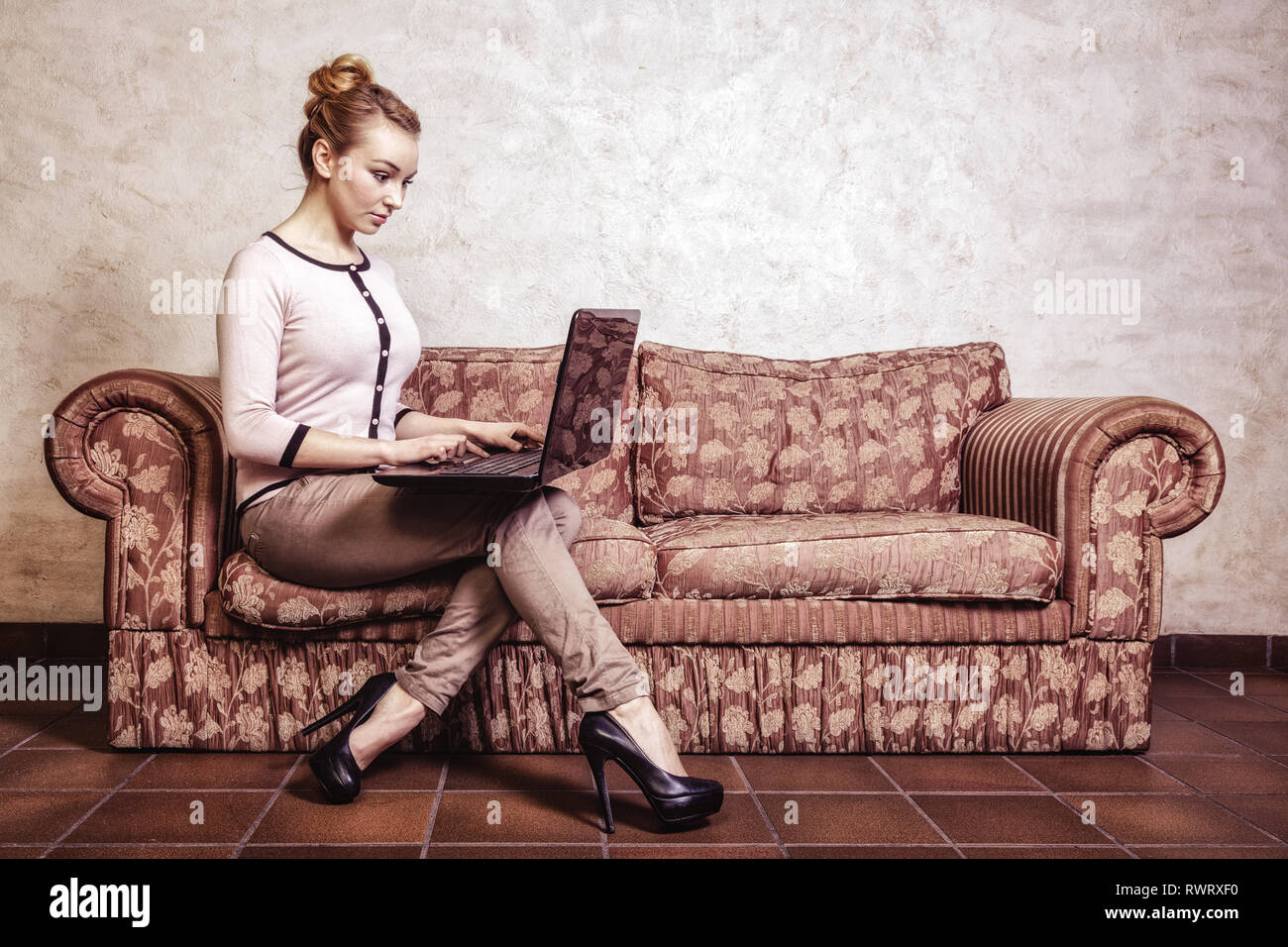 Internet technologie concept de vie moderne. Jeune femme d'affaires pleine longueur ou étudiant girl using laptop computer sitting on table rétro Banque D'Images