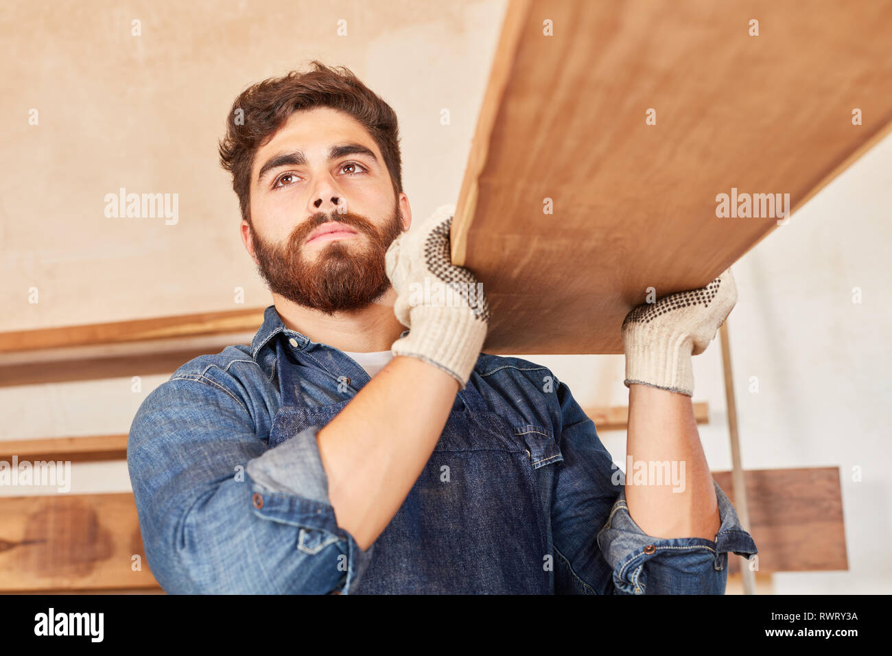 Jeune Homme Comme Charpentier Ou Menuisier Dans La Formation Comporte Des Poutres En Bois Photo Stock Alamy