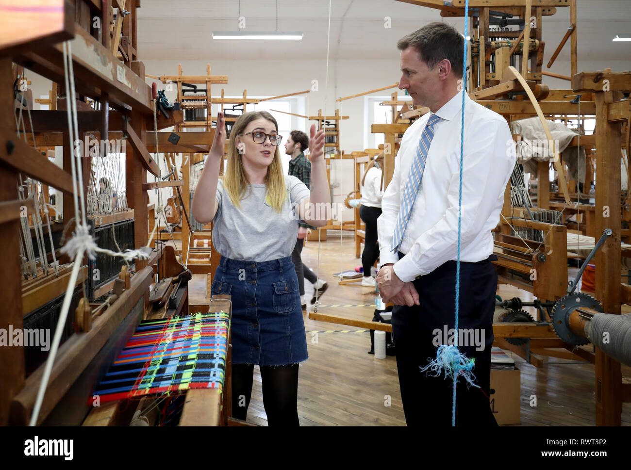 Secrétaire des affaires étrangères rencontre Jeremy Hunt Heather étudiant Dowie (gauche) dans la salle de tissage au cours d'une visite à l'École de textile et de design de l'Université Heriot Watt campus à Galashiels. Banque D'Images