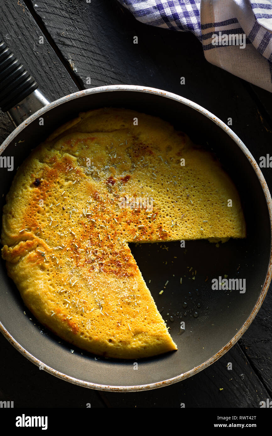 Pois chiches Vegan tranchés omelette sur une poêle Banque D'Images