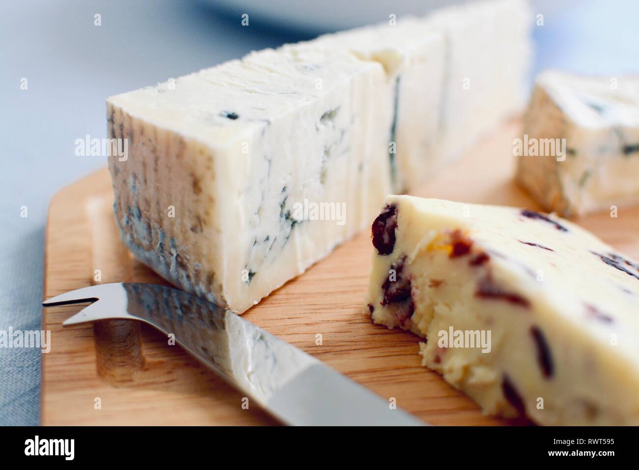 Vue rapprochée d'un plateau de fromage avec un couteau à fromage servi sur une planche en bois Banque D'Images