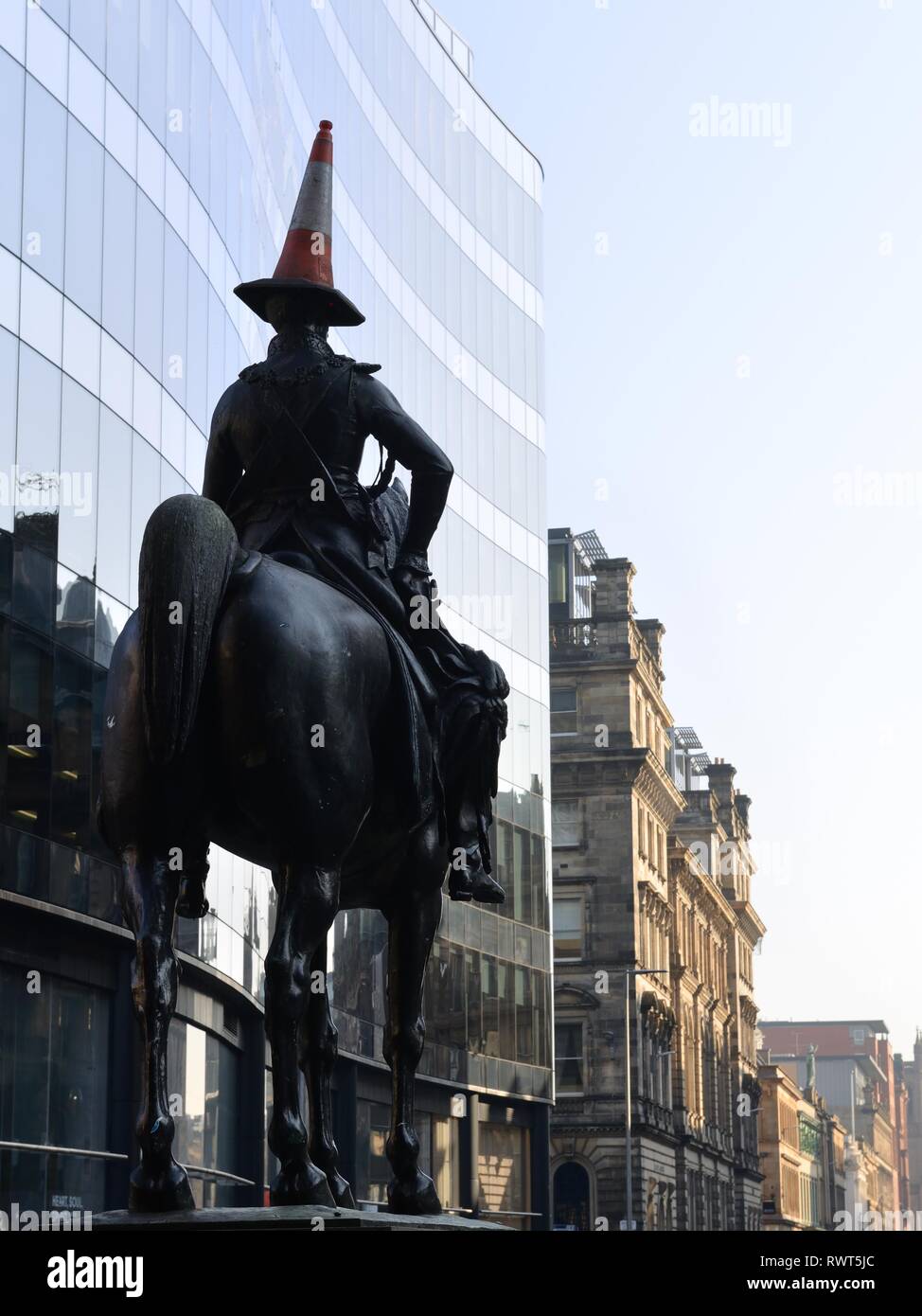La célèbre statue du duc de Wellington du cheval et du cavalier avec le cône de trafic plus humoristique sur la tête à Glasgow, Écosse, Royaume-Uni, Europe. Banque D'Images