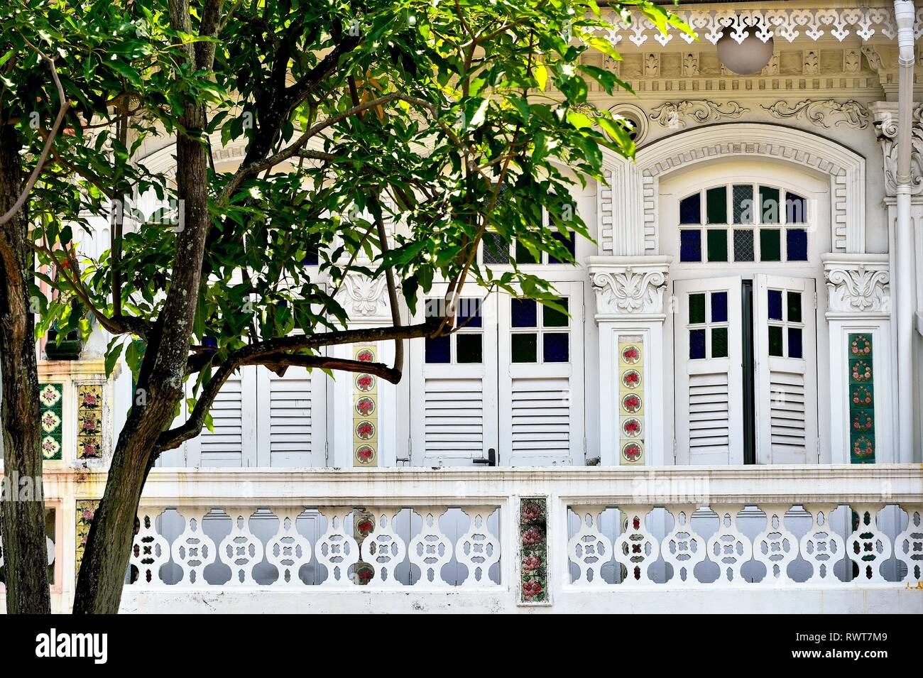 Vintage fenêtres cintrées avec des volets en bois et balcon de pierre sur l'extérieur blanc de Singapour shophouse historique Peranakan dans Little India Banque D'Images