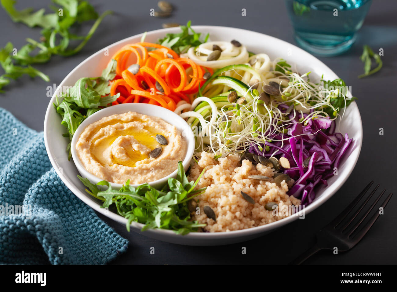 Couscous aux légumes déjeuner bol avec spiralazed les carottes et la courgette, l'hoummos et de chou rouge Banque D'Images