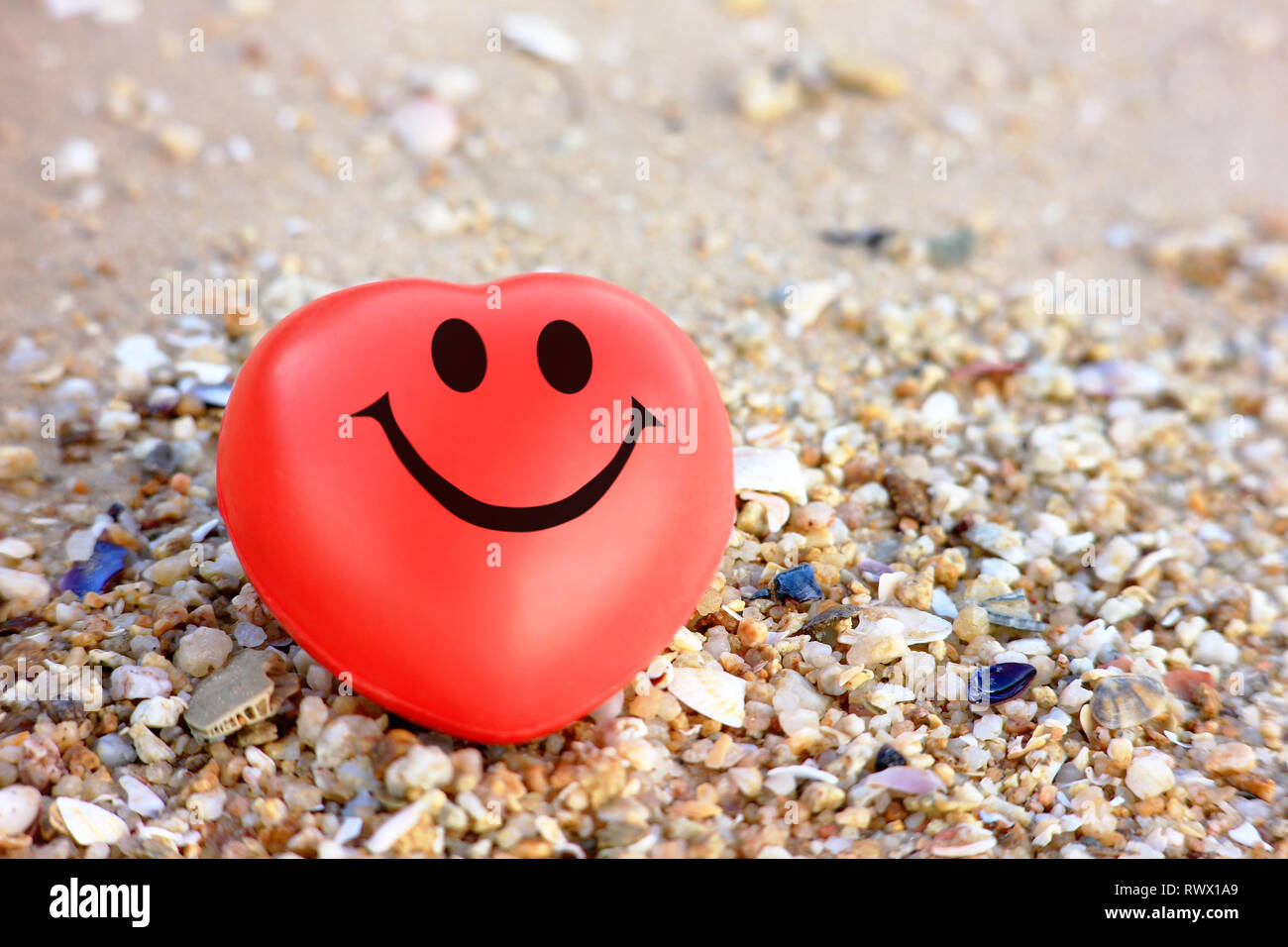 Coeur rouge sourire avec fond de sable Banque D'Images