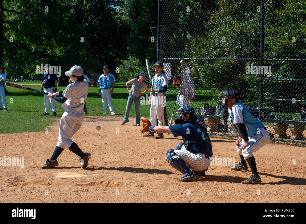 Vue d'un match de baseball dans Central Park à New York grâce à une maille clôture. Catcher s voir un match de baseball de Central Park à New York. Central Park Banque D'Images
