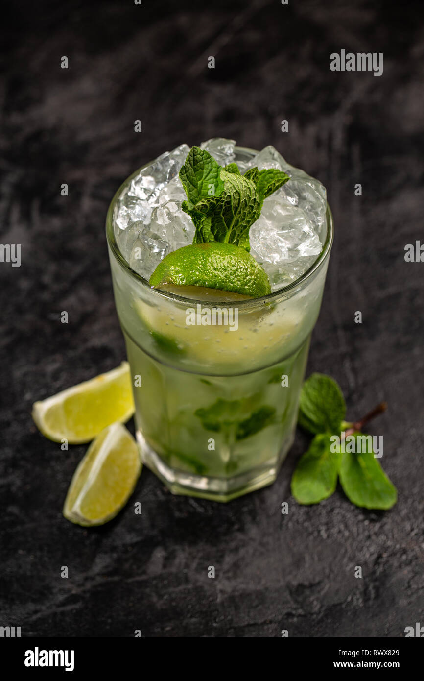 La menthe rafraîchissante mojito cocktail au rhum et citron vert, boisson froide ou de boissons avec de la glace sur fond noir Banque D'Images