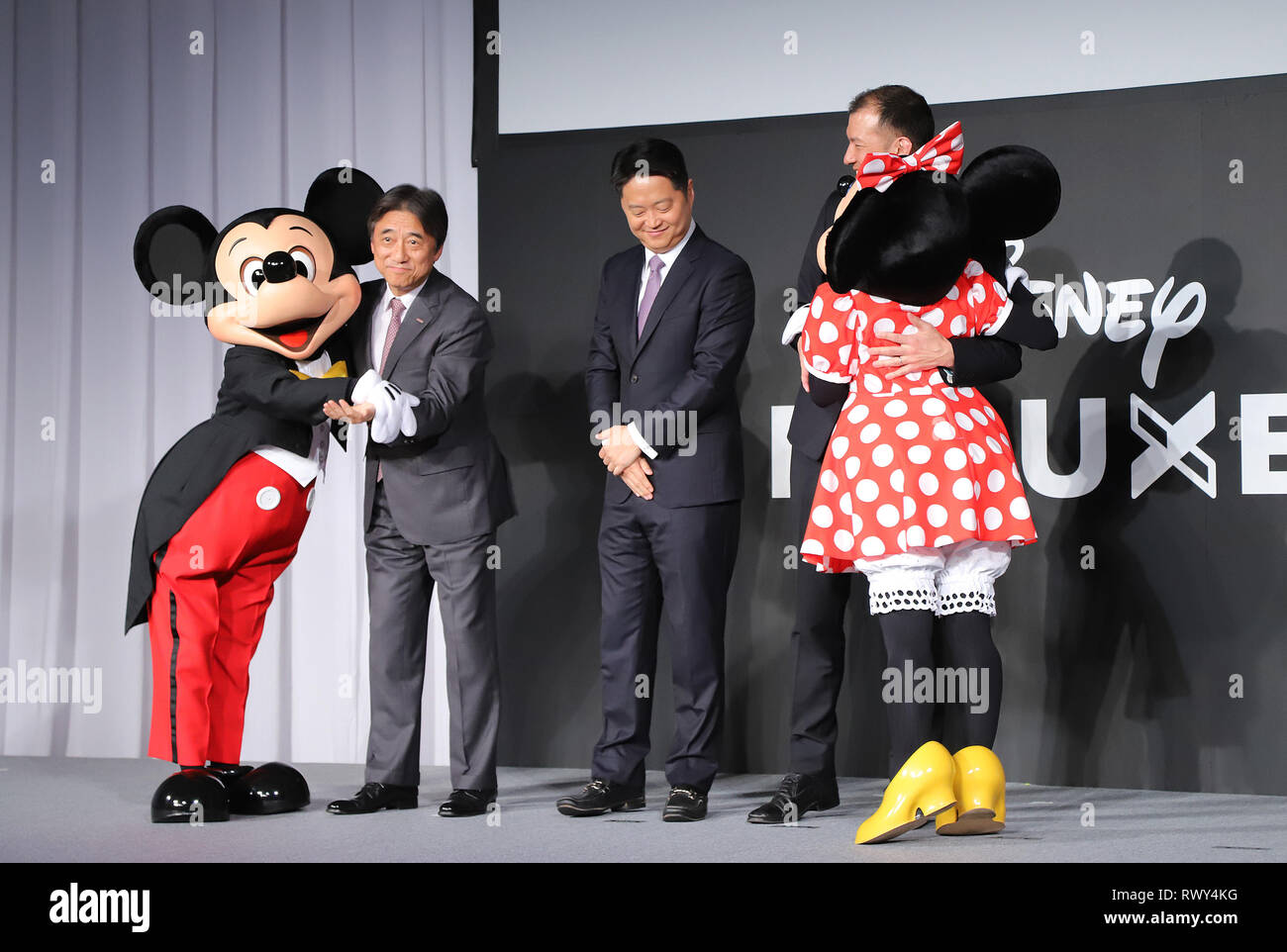 Tokyo, Japon. 7 mars, 2019. Le Japon de la téléphonie mobile NTT Docomo géant communication président Kazuhiro Yoshizawa (2L), Walt Disney vice-président et directeur général de l'Asie du Nord Luc Kang (C) et Walt Disney Japon vice-président Tony Elison (2e R) sourire avec les personnages Disney Mickey (L) et Minnie (R) comme ils l'annoncent NTT Docomo va démarrer service de distribution vidéo de Walt Disney's 'Contenu' De Luxe Disney à travers le réseau DOCOMO avec un prix fixe à partir de ce mois, à une conférence de presse à Tokyo, le Jeudi, Mars 7, 2019. Credit : Yoshio Tsunoda/AFLO/Alamy Live News Banque D'Images