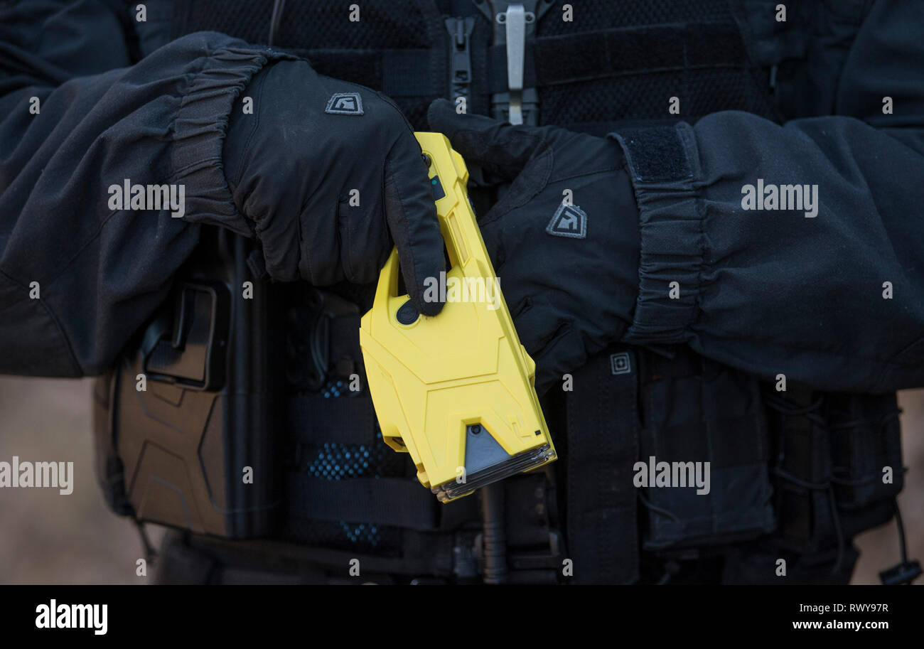 Wiesbaden, Allemagne. Feb 25, 2019. Denis Altvater de l'escouade des vols de la police de Francfort est titulaire d'un Taser dans sa main. Après une phase de test, les fusils paralysants fera partie de l'équipement standard des agents cette année. Le Taser est considérée comme un "non-létale" et les incendies deux barbelés par lequel 50 000 volts dans le corps de la personne touchée. Le courant entraîne une contraction musculaire, qui place la victime hors d'action pendant quelques secondes. Credit : Boris Roessler/dpa/Alamy Live News Banque D'Images