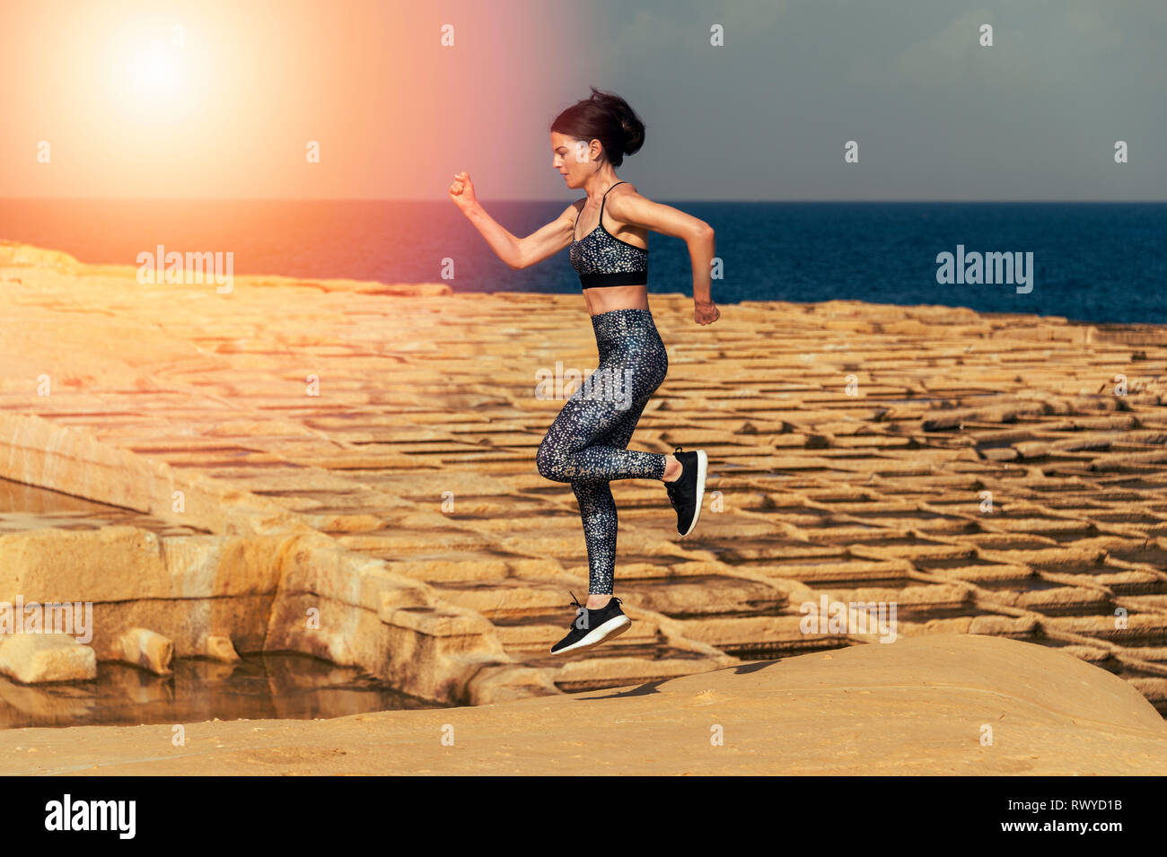 Woman runner, course à travers les marais salants de calcaire à Malte. Banque D'Images
