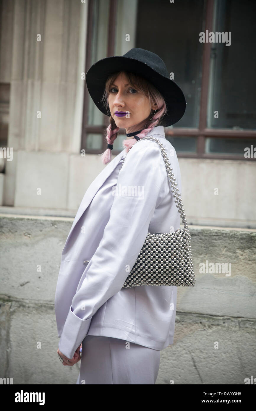 LONDON - 15 février 2019 : les participants à l'extérieur rassemblement élégant 180 The Strand pour la Semaine de la mode de Londres. jeune fille dans un costume gris, avec un sac de cordon d'argent Banque D'Images