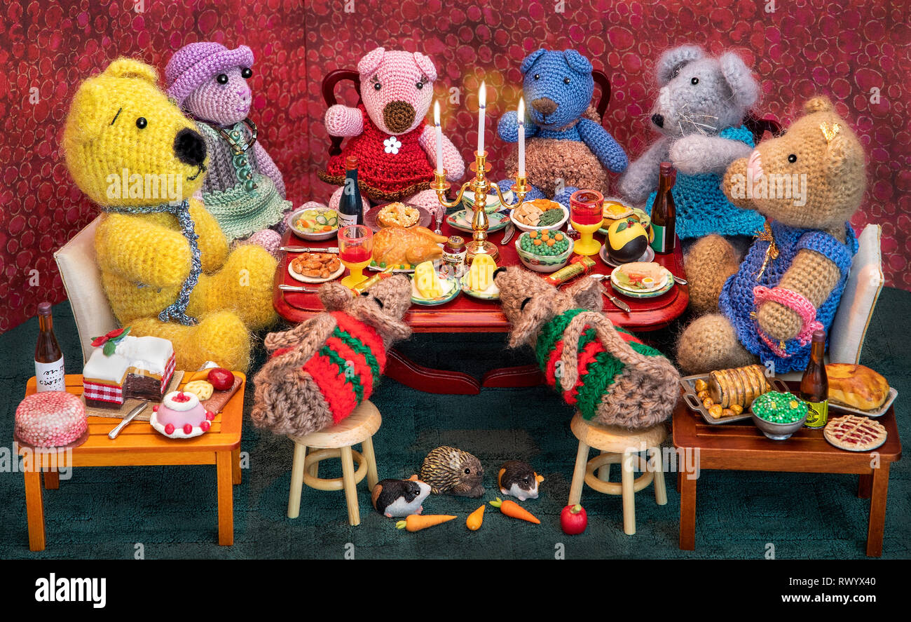 Miniture modèles au crochet (avec presse) s'asseoir pour un dîner de slap-up, prises pour des cartes de Noël ou des livres pour enfants. Banque D'Images