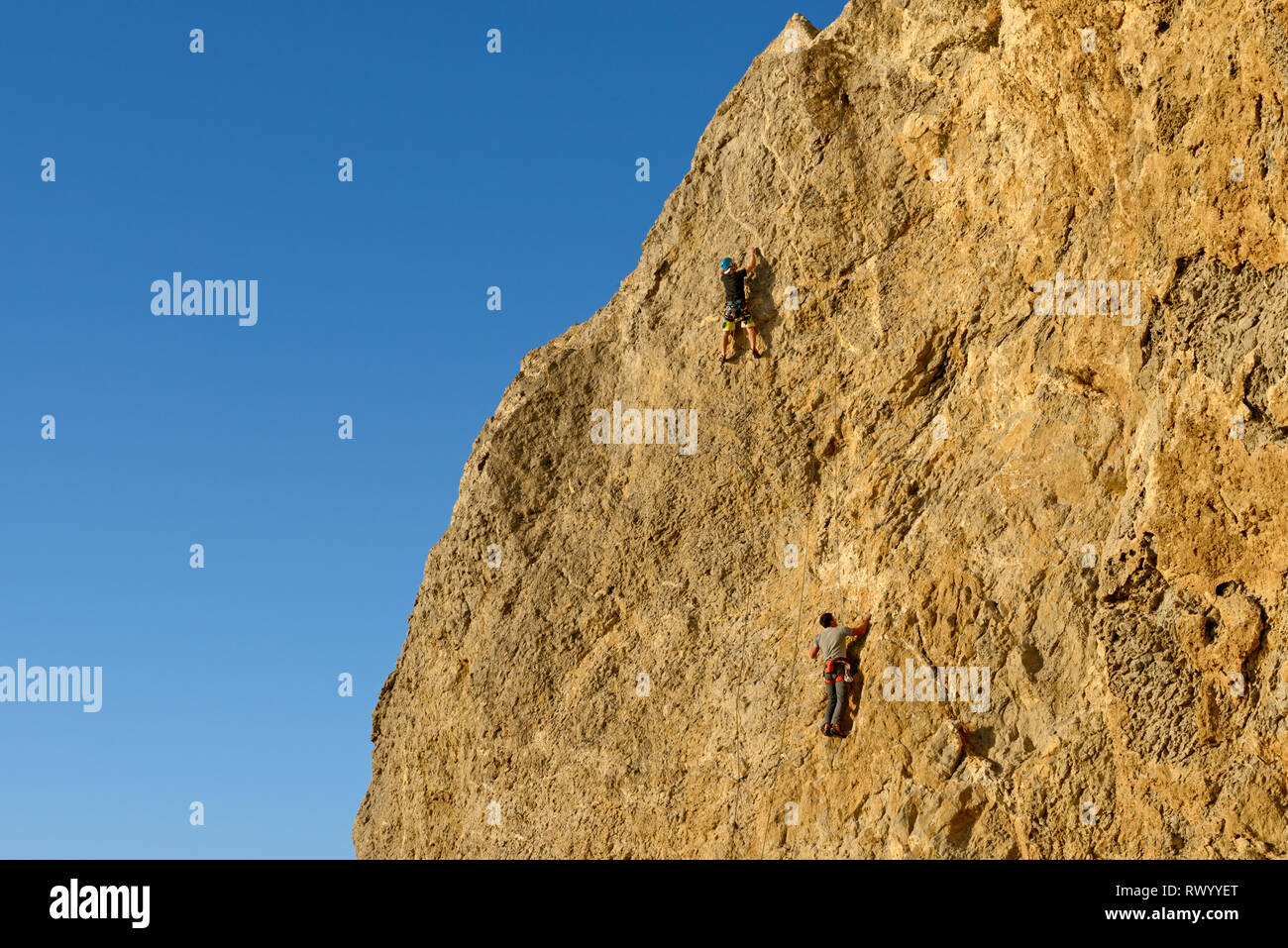 Deux hommes sont à l'escalade sur les cordes d'assurage mur vertical d'Alchak la montagne du cap à Sudak, Crimée, la Russie. Banque D'Images