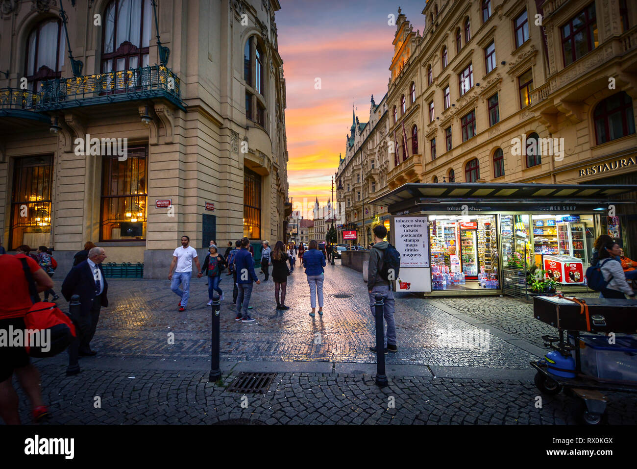 Les touristes et les République Tchèque profitez d'un coucher du soleil brillant à l'extérieur d'un petit magasin sur la place de la République avec les tours de Tyn de vieille ville de voir à Prague, République Tchèque Banque D'Images