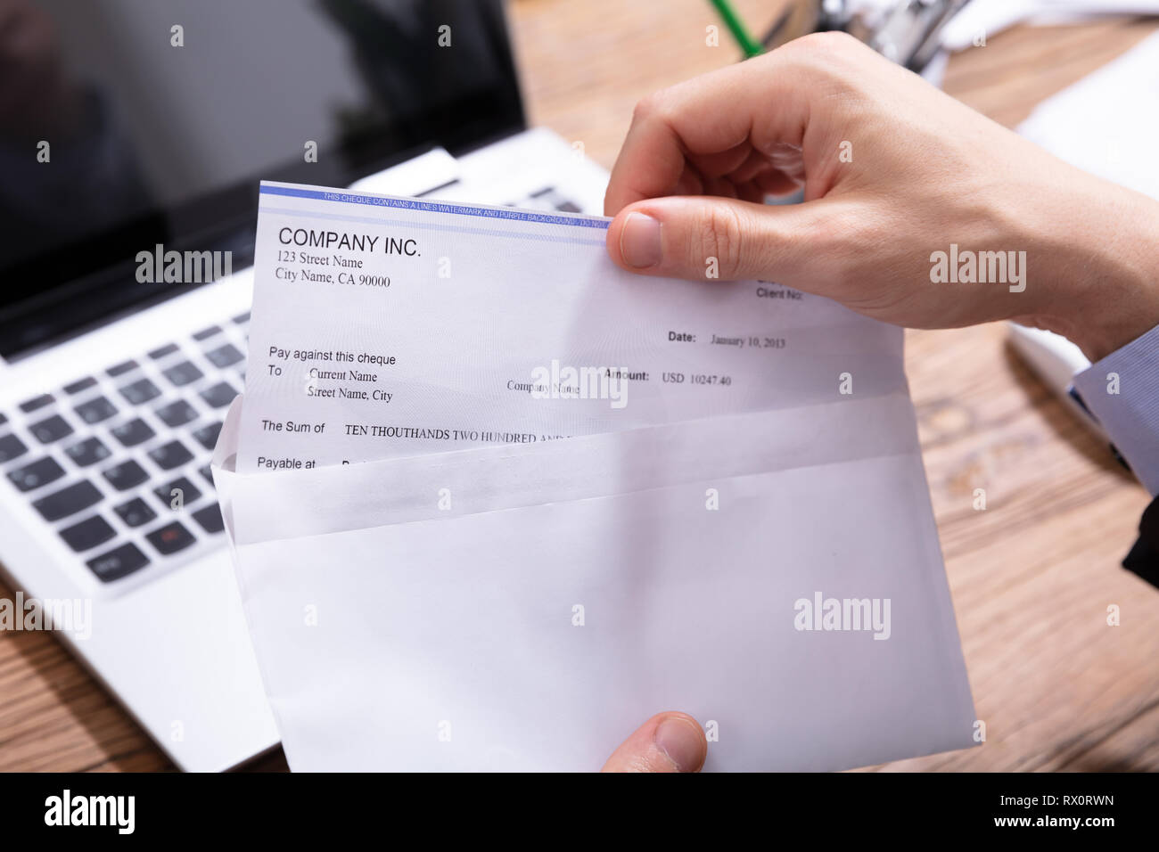 Close-up de l'homme d'affaires d'ouverture de l'enveloppe avec un chèque en bois de plus de 24 Banque D'Images