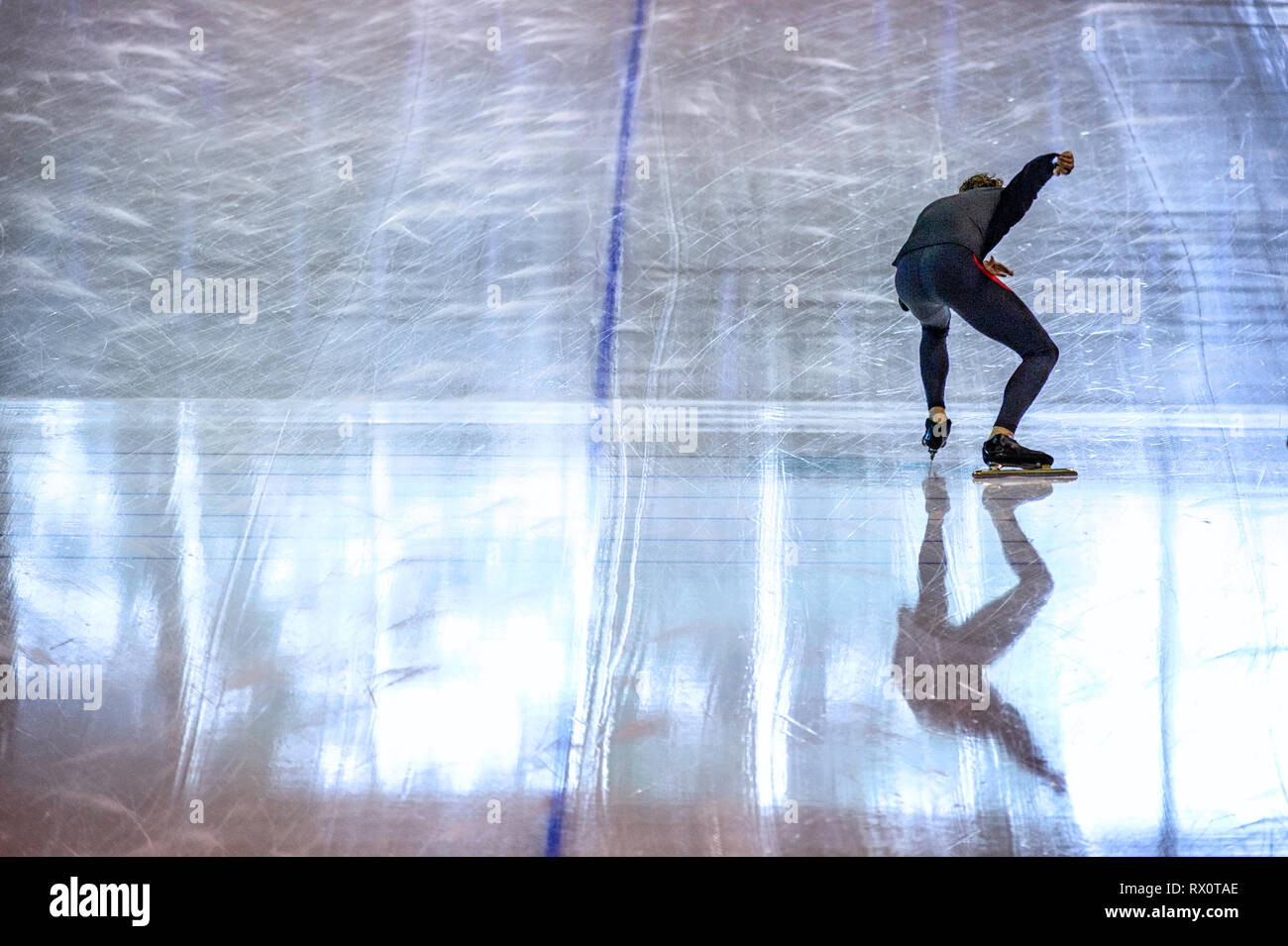 La patineuse de vitesse dans la formation sportive, pratiquant à la ligne de départ d'un anneau de patinage de vitesse Banque D'Images