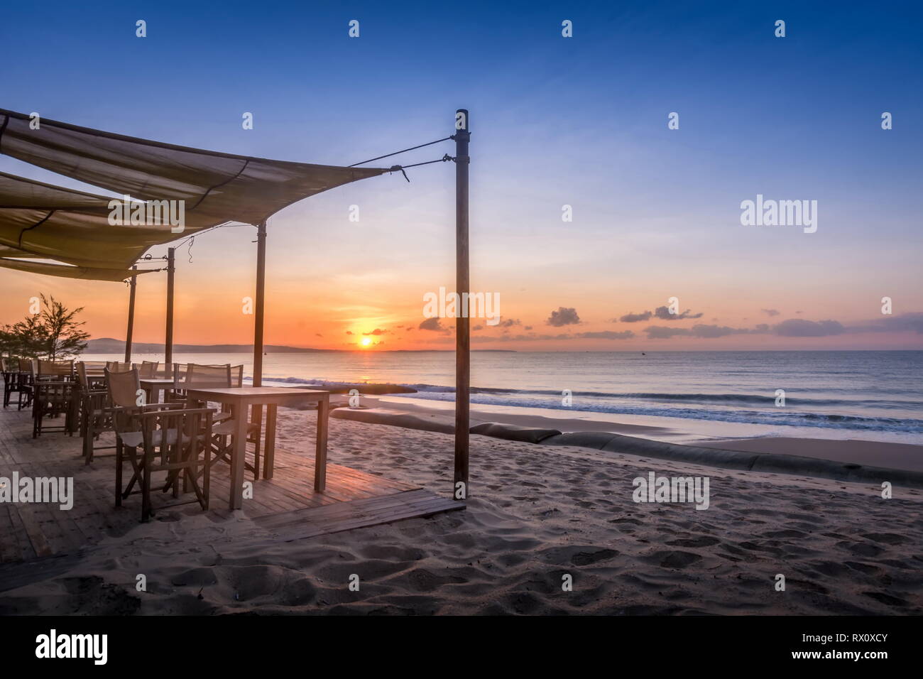 Paysage Tropical beach resort avec chaise, des parasols et une terrasse au lever du soleil Banque D'Images