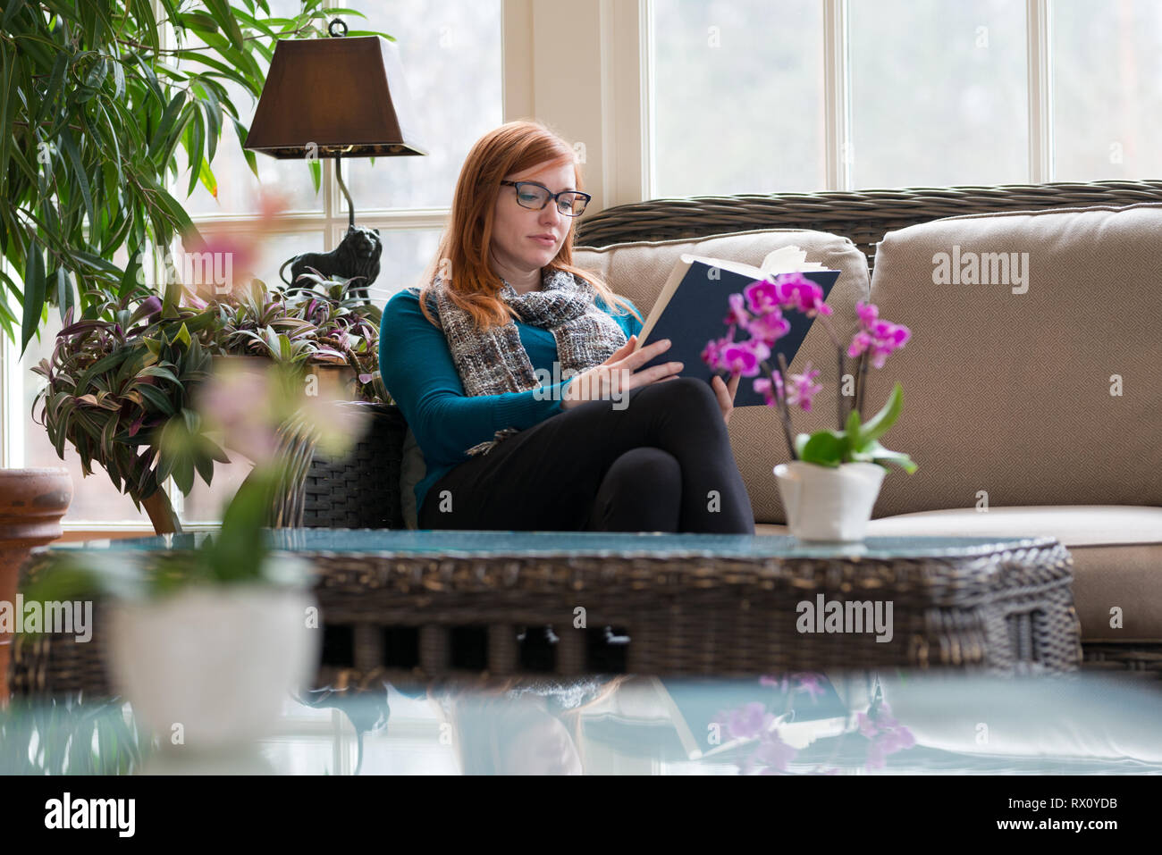Jolie femme utilise le temps libre et le grand design d'intérieur pour la lecture l'apprentissage de l'amélioration Banque D'Images