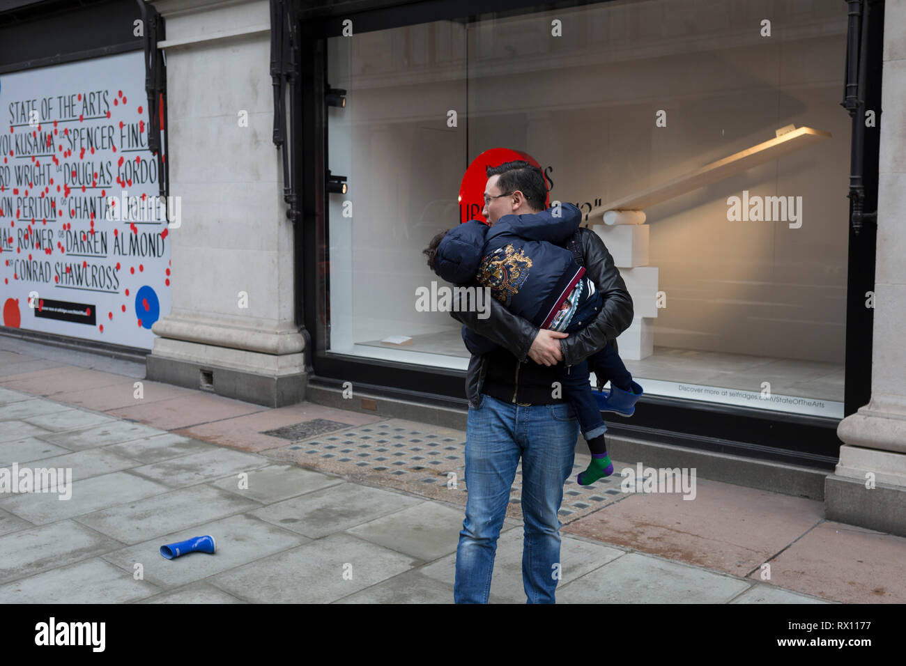 Une famille asiatique lutte avec un boot bleu à l'extérieur d'une fenêtre affiche cette fait partie d'un thème de conception appelé "état de l'art", au grand magasin Selfridges sur Oxford Street, le 4 mars 2019, à Londres en Angleterre. La situation des arts est une galerie d'œuvres de neuf artistes-crtically dans Selfridges windows pour célébrer le pouvoir de l'art public. Chacun des artistes impliqués dans la création d'un site d'art spécifiques à l'une des nouvelles stations de la ligne d'Elizabeth dans le cadre du Programme d'Art de la traverse. Banque D'Images Une famille asiatique lutte avec un boot bleu à l'extérieur d'une fenêtre affiche cette fait partie d'un thème de conception appelé "état de l'art", au grand magasin Selfridges sur Oxford Street, le 4 mars 2019, à Londres en Angleterre. La situation des arts est une galerie d'œuvres de neuf artistes-crtically dans Selfridges windows pour célébrer le pouvoir de l'art public. Chacun des artistes impliqués dans la création d'un site d'art spécifiques à l'une des nouvelles stations de la ligne d'Elizabeth dans le cadre du Programme d'Art de la traverse. Banque D'Images