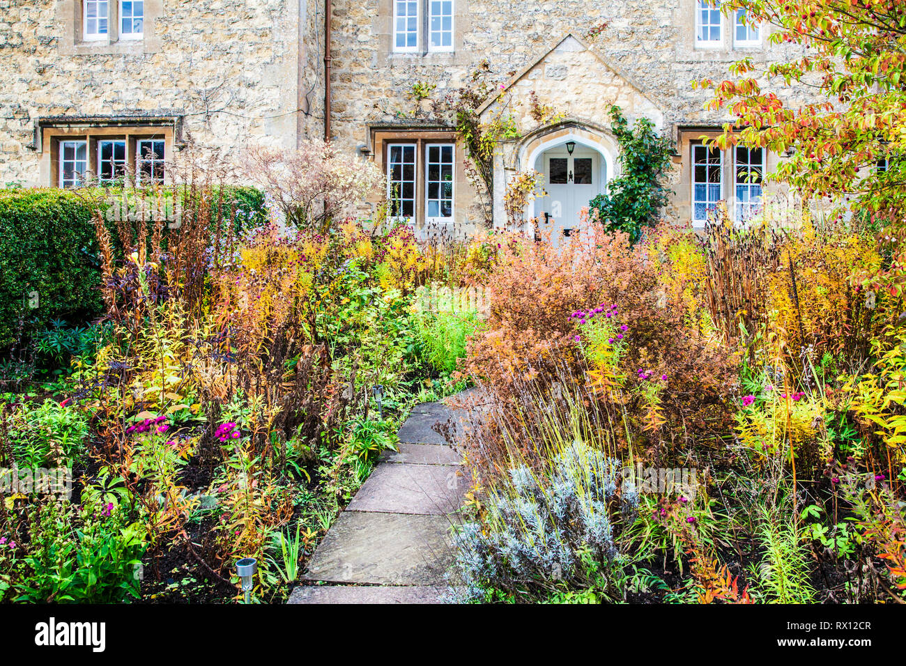 Le jardin avant l'automne d'un cottage en pierre dans la région des Cotswolds, en Angleterre. Banque D'Images