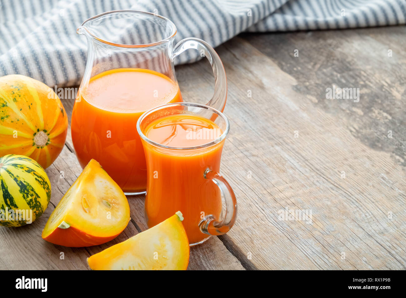 Tasse et pichet de jus de citrouille frais et des citrouilles sur table. L'espace de copie pour le texte. Banque D'Images