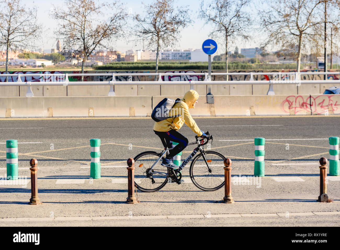 Valence, Espagne - 28 Février 2019 : les cyclistes qui transitent par une bande cyclable à proximité d'une route sans trafic avec direction. Banque D'Images
