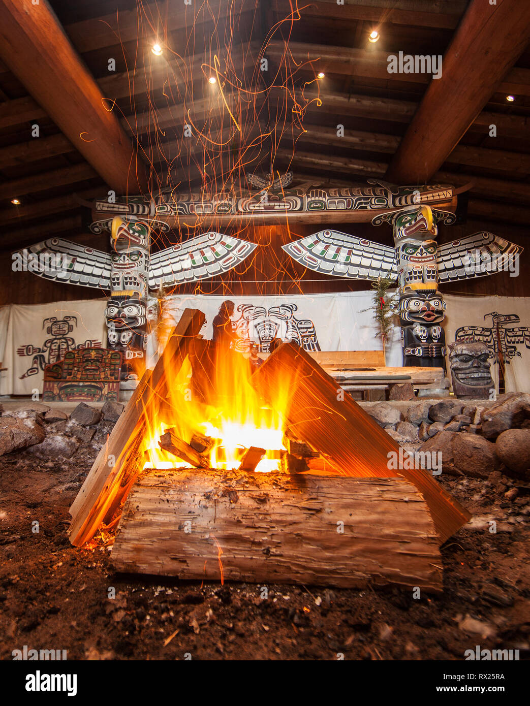 Un feu brûle dans le milieu de la grande maison à Alert Bay, l'île Cormorant, British Columbia, Canada. Banque D'Images