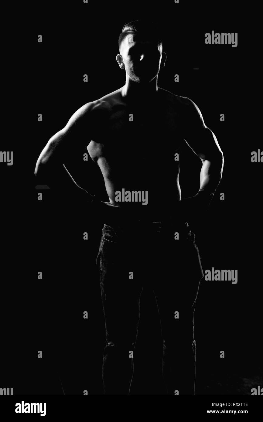 Portrait Silhouette d'un jeune homme en bonne forme physique montrant son corps bien formé - Athletic musculaire Fitness Model Posing Bodybuilder Exercices après Banque D'Images