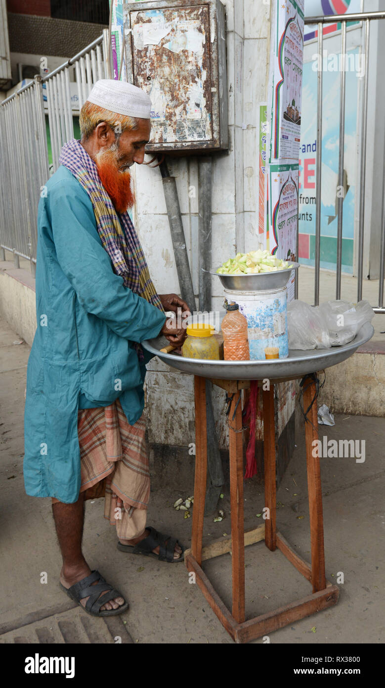 Un vendeur de préparer la goyave Masala- un snack sucré et épicé populaires au Bangladesh. Banque D'Images